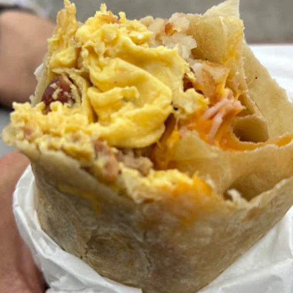 Nachos topped with cheese sauce, lettuce, and grated cheese