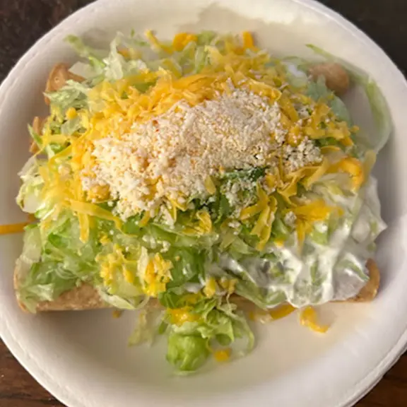 Fresh lettuce salad topped with shredded cheese and grated cheese